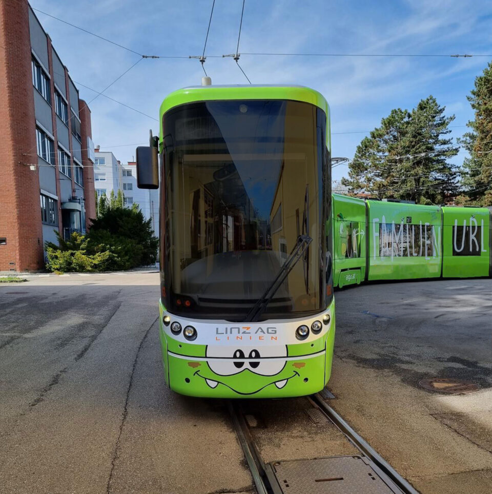Straßenbahn mit grüner AIGO Beschriftung in Linz - AIGO Familienhotel