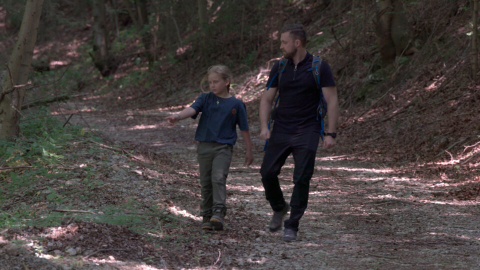 Vater und Kind spazieren im Wald