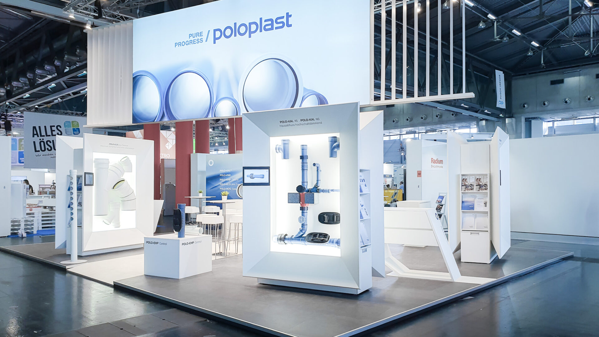 Weitwinkelaufnahme des POLOPLAST-Messestands mit mehreren Exponatmodulen, Produktinszenierungen und großzügiger Standarchitektur für Besucherführung und Markenkommunikation.